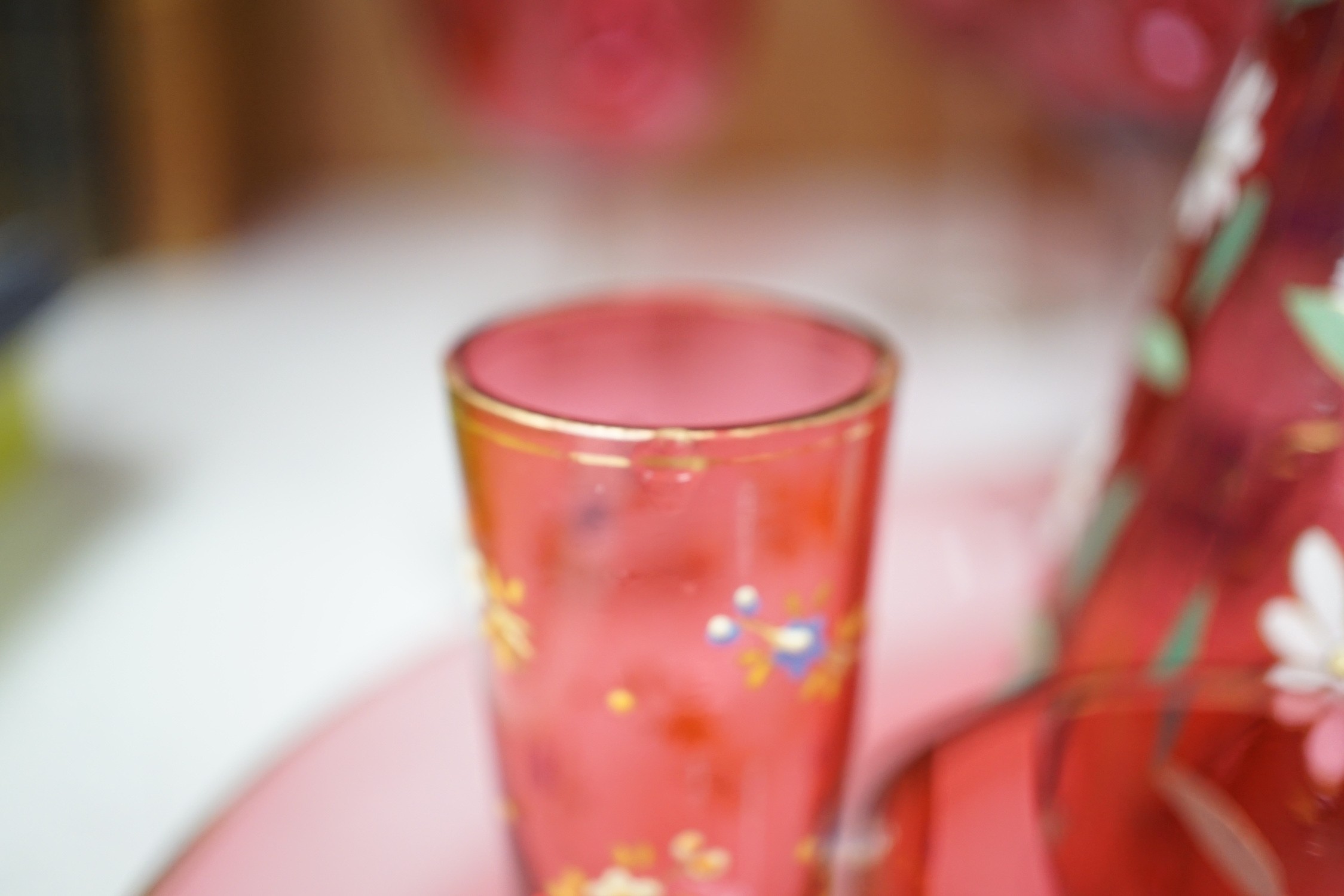 A collection of cranberry glass, a dump paperweight, another and a sweetmeat jar, tallest 28.5 cm